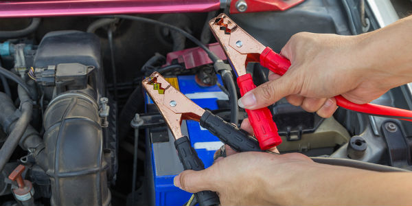 Hands holding jumper cables