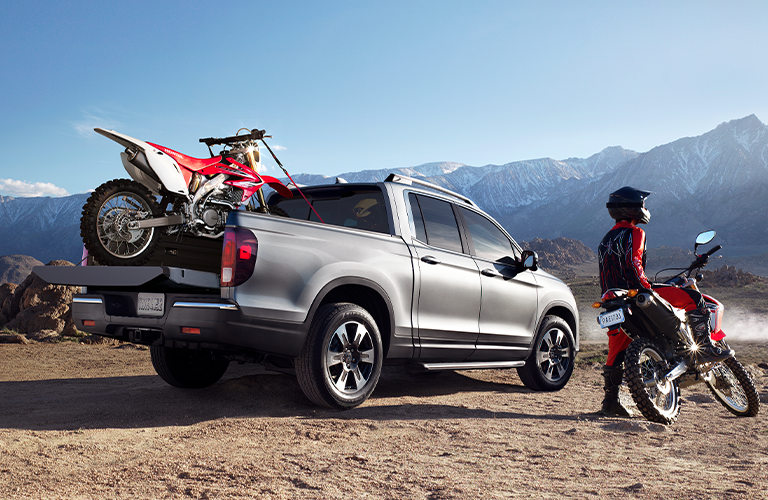 Silver 2020 Honda Ridgeline with dirt bike in truck bed