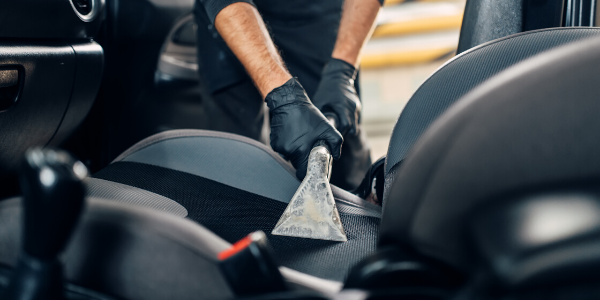 Mechanic vacuuming vehicle seat