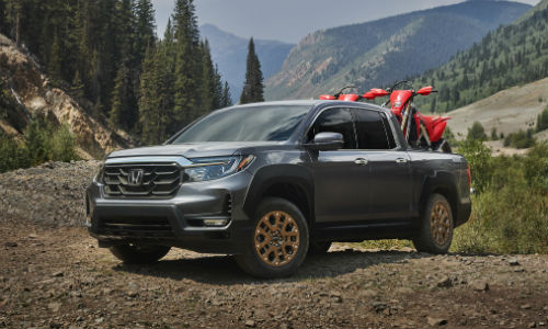 Gray 2021 Honda Ridgeline on dirt with two dirt bikes in truck bed