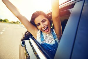 happy woman leaning out of a car window